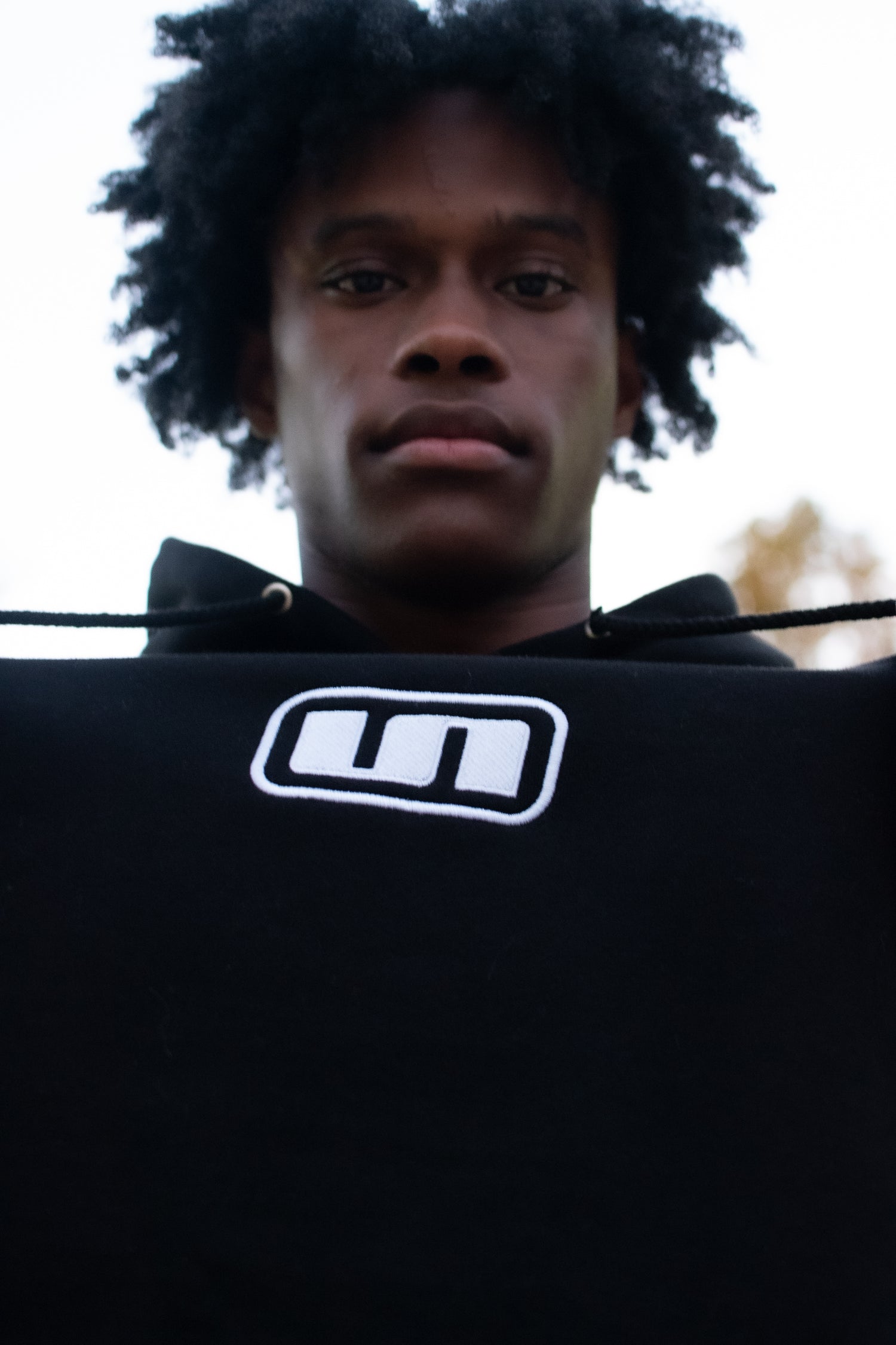 Model wearing the UNLONELY Box Logo Hoodie in the Black colorway.